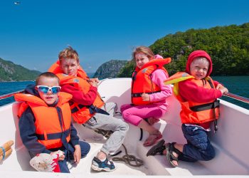 The kids in a lifejackets go for a row